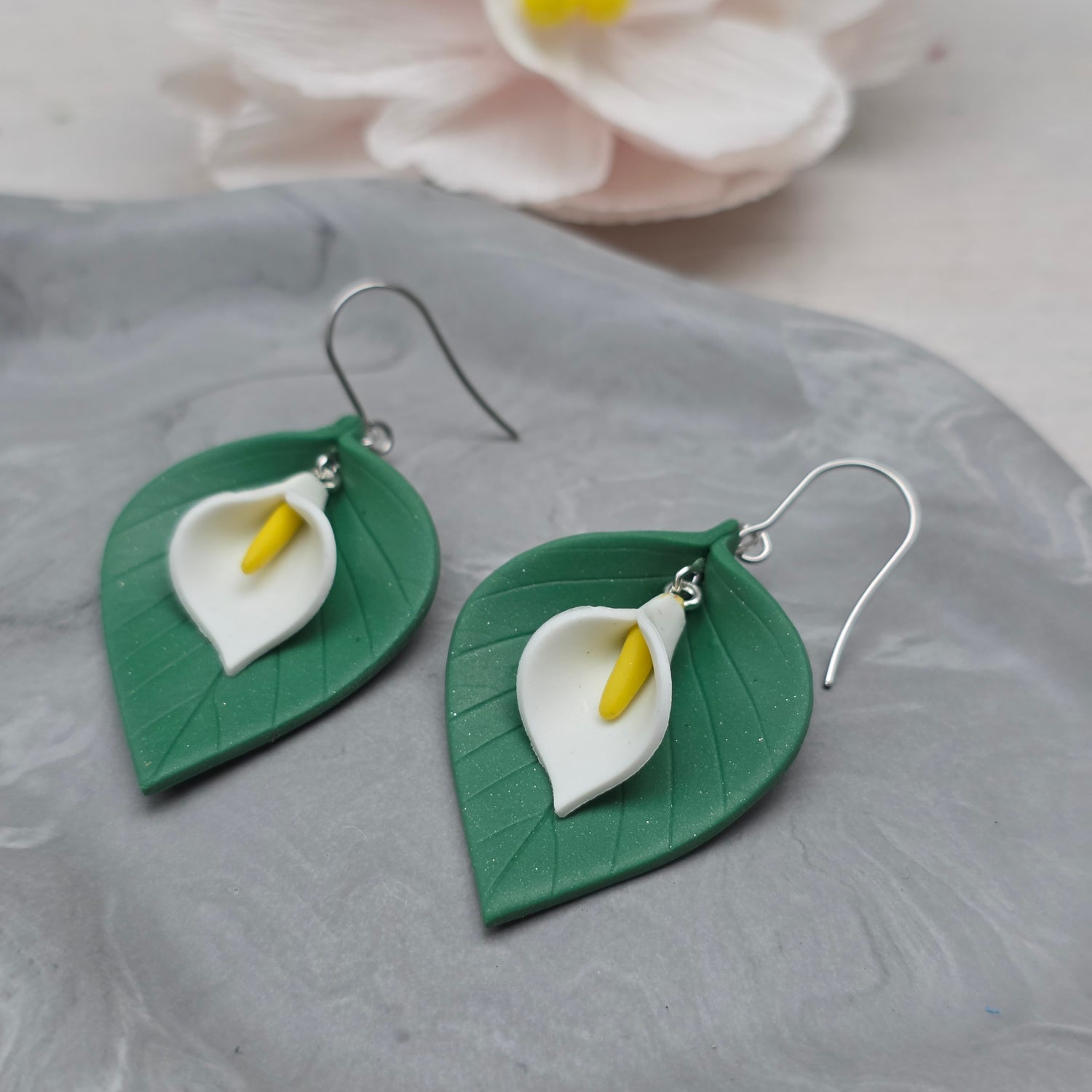 Oorhangers blad met witte kelkbloem